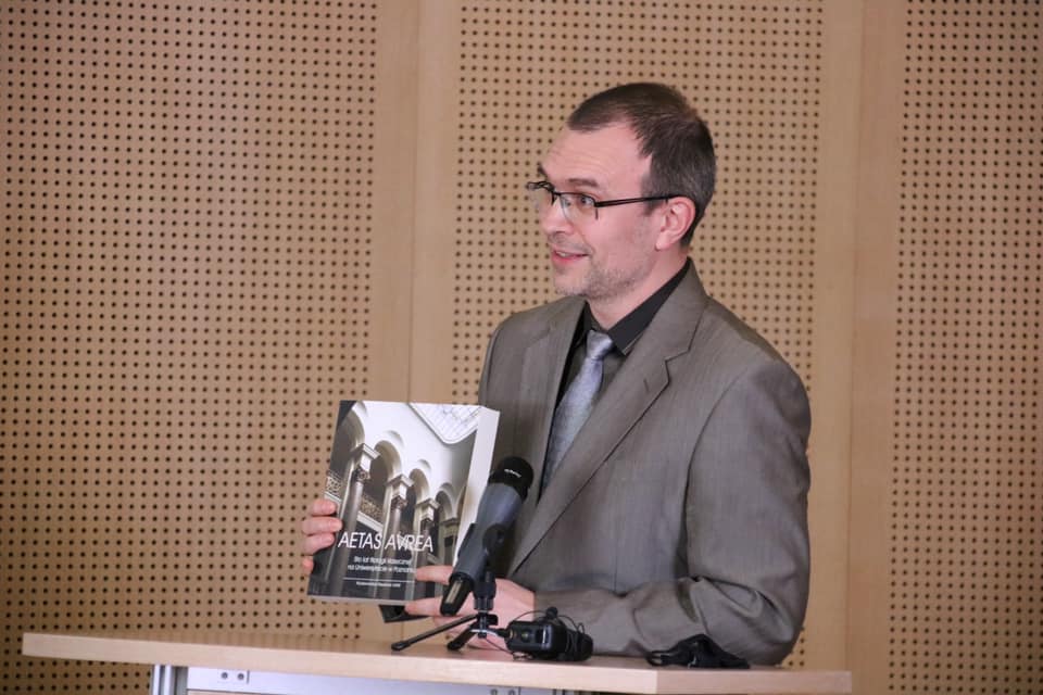 Zdjęcie z jubileuszu w Salonie Mickiewicza. Prof. Mateusz Stróżyński przemawia do mikrofonu, prezentując książkę.