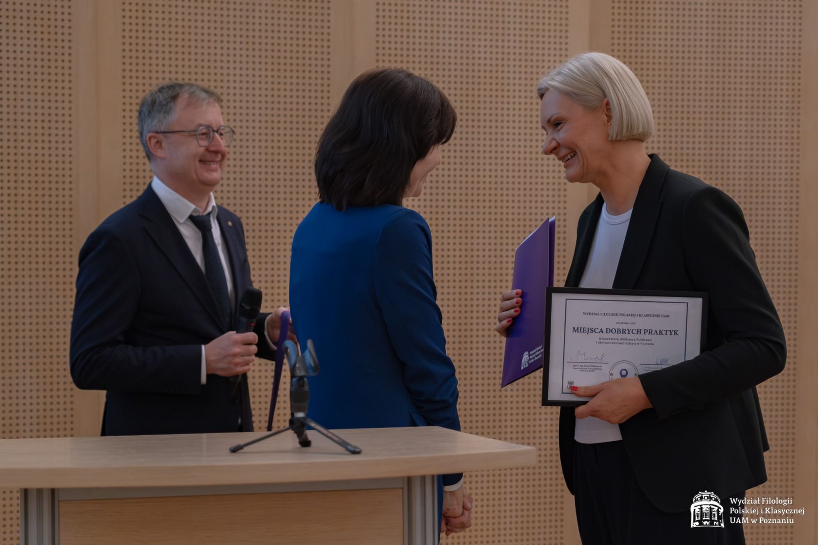 Prof. Elżbieta Winiecka gratuluje kobiecie w średnim wieku, która trzyma w ręce dyplom 