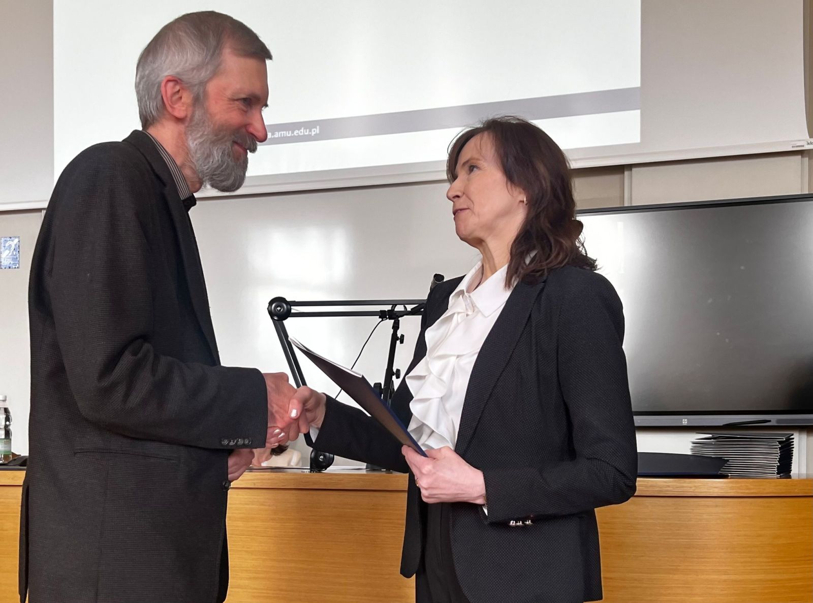 Prof. Elżbieta Winiecka, dyrektorka IFP, wręcza powołanie prof. Markowi Wedemannowi.